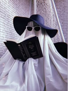 a ghost reading a book wearing sunglasses and a hat