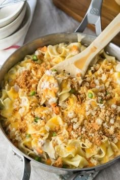 a skillet filled with pasta and meat on top of a table