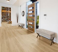 an empty room with white walls and wood flooring on the side, along with two benches