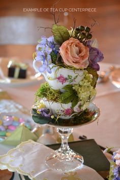 there is a cake with flowers on the top and green leaves on the bottom, sitting on a table