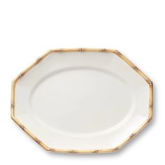 a white and gold plate with bamboo trimmings on the rim, against a white background