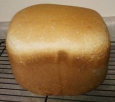 a loaf of bread sitting on top of a wire rack next to a wall and floor