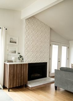 a living room with a couch, fireplace and large wall paper on the back wall