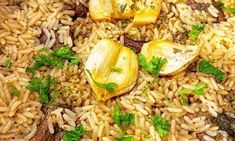 rice and vegetables are being cooked in a pan with parsley on the top side