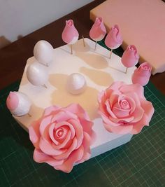 a cake decorated with pink roses and white balls