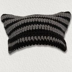 a gray and black crocheted pillow on a white background