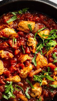 a skillet filled with chicken and tomato sauce