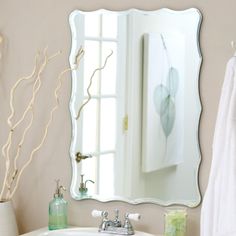 a bathroom sink sitting under a mirror next to a white towel hanging on a rack