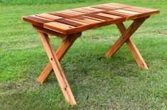 a wooden bench sitting on top of a lush green field