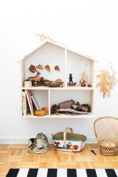 a doll house shelf with toys and books on it