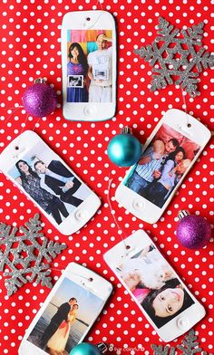 four cell phones with christmas photos on them next to silver and red ornaments, snowflakes and balls