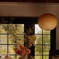 a vase filled with flowers sitting on top of a wooden table next to a window