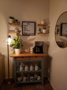 there is a coffee bar with plants on the shelf next to it and a mirror