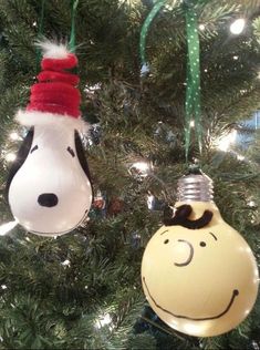 two ornaments hanging from a christmas tree decorated with peanutshells and an ornament