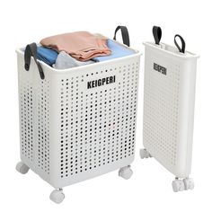 two white laundry baskets with black handles and one has a pink shirt on top, while the other is blue