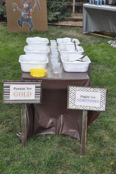 there are many bowls on the table with signs in front of them that say paint for gold