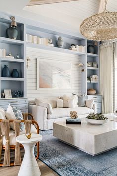 a living room with white furniture and blue walls