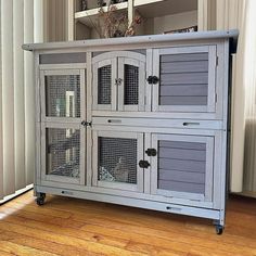 a grey cabinet sitting on top of a hard wood floor