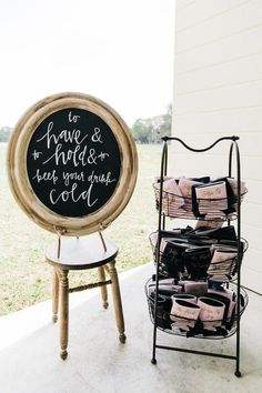 a chalkboard sign next to a stack of books on a chair and a small table