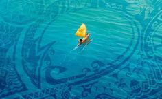 an aerial view of a yellow sail boat in the ocean with intricate designs on it