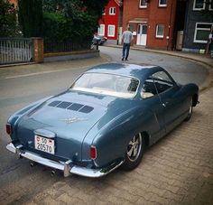 an old car is parked on the side of the road