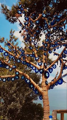 a tree with blue glass eyes hanging from it's branches