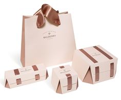 three boxes with ribbons on them sitting next to each other in front of a white background