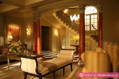 an elegant living room with checkered flooring and chandelier in the center