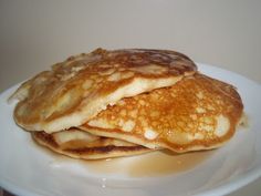 two pancakes on a white plate with syrup