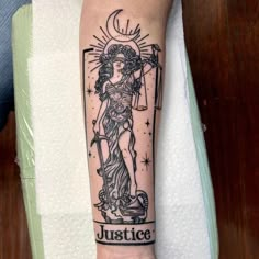 a lady justice tattoo on the arm