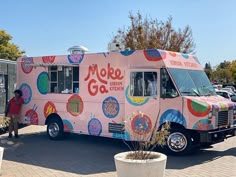 a pink ice cream truck parked in a parking lot