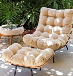 a chair and ottoman in front of some plants