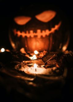 a jack - o'- lantern lit up in the dark, with candles inside