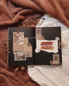 an open book on top of a bed next to a pair of eyeglasses