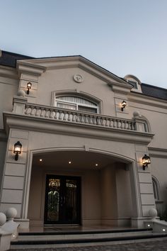 the front entrance to a large house with steps leading up to it's door