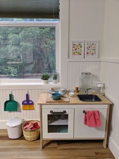 a play kitchen with sink, stove and window