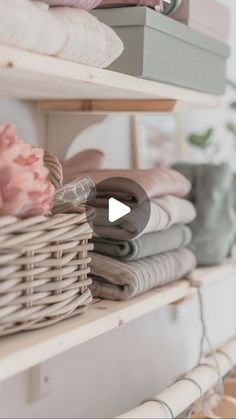 the shelves are full of folded clothes and baskets with flowers on them, along with other items