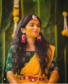 a woman in yellow and green dress sitting down