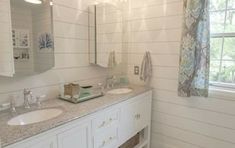 a bathroom with two sinks and a large mirror above the sink is decorated in blue and white