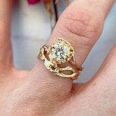 a close up of a person's hand with a gold ring on their finger