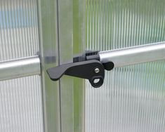 a close up of a door handle on a glass door with blinds in the background