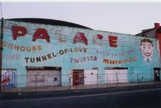 an old building has been painted blue and says papae on the side, in front of other buildings