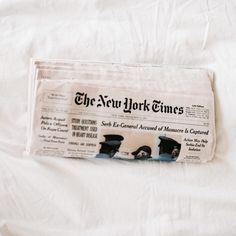 a newspaper laying on top of a bed with the new york times printed on it