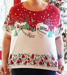 a woman standing in front of a christmas tree wearing a red and white ugly sweater