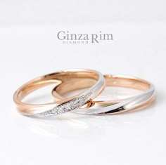 two gold and white wedding rings with diamonds on them, sitting side by side against a white background