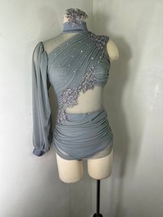 a mannequin wearing a gray dress with silver sequins on the shoulders