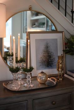 a table topped with candles next to a mirror and vases on top of it