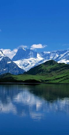 the mountains are reflected in the still water