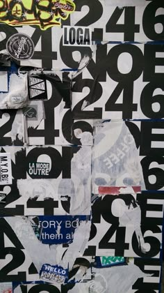 a wall covered in lots of different types of stickers and numbers with graffiti on it