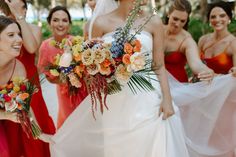 a bride and her bridesmaids are all dressed in red, orange, yellow and white